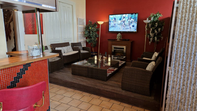 Rote Lounge mit Sofas, Kamin und Blick zur Bar.